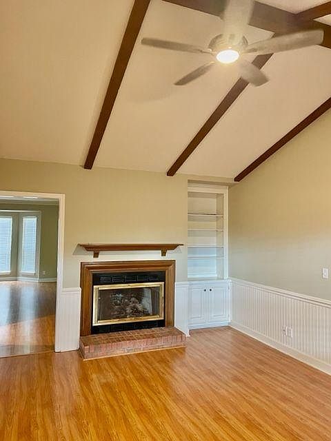 Den with vaulted ceiling, new ceiling fan, and fireplace.