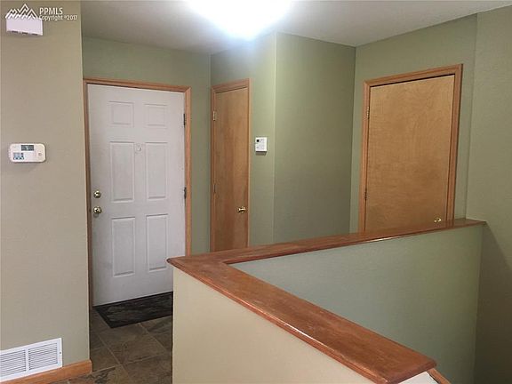 Ceramic-tiled entryway with coat closet and entrance into 2-car garage.
