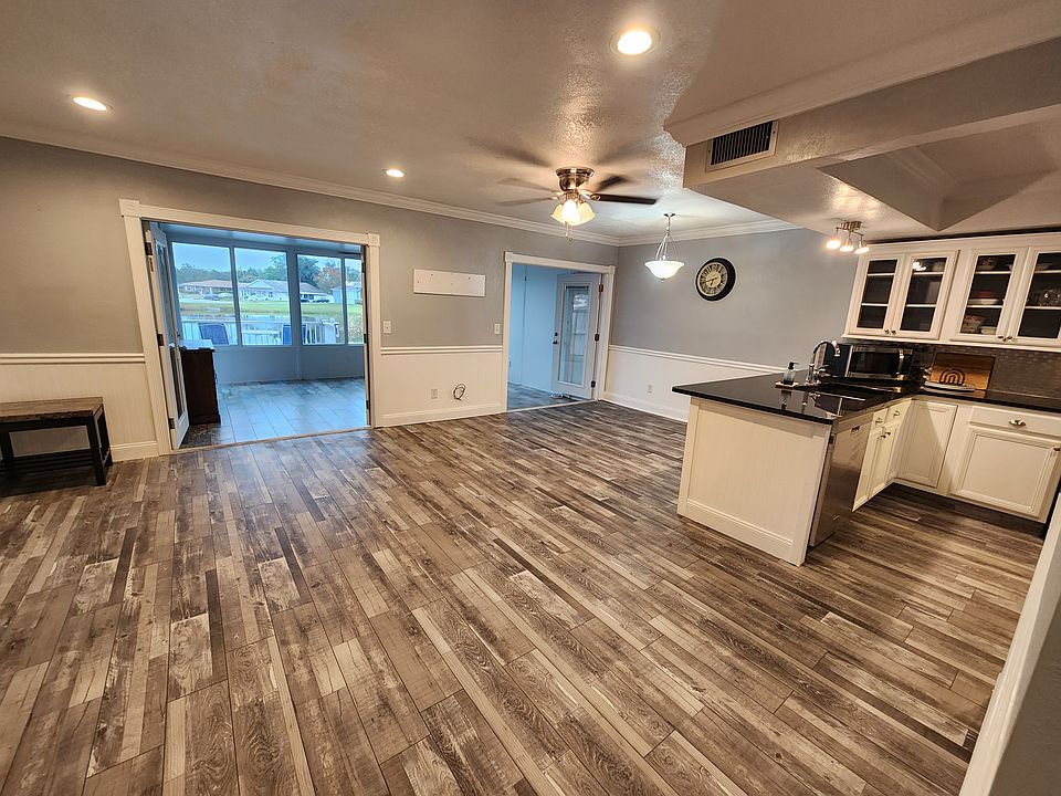 Open layout living room, dining space and kitchen. Double french doors open to all-season room.