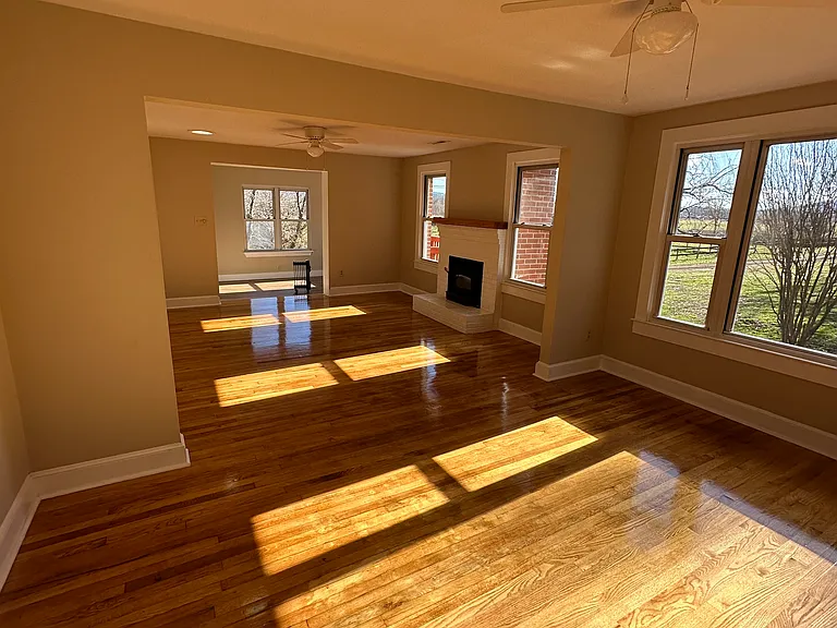 Dinning / Living area with fireplace has oak hardwood flooring. 

Access to the kitchen is from the right. At the far side is the main entrance.