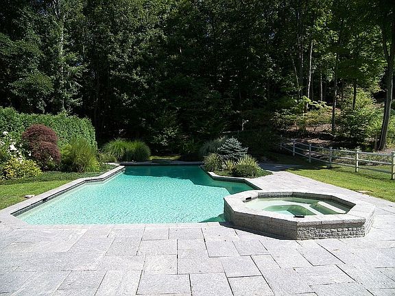 Pool with granite patio and hot tub