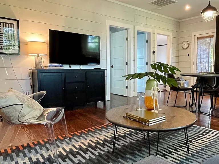 Unwind in a comfortable, inviting living room featuring cozy seating, abundant natural light, and a large Roku Smart TV for streaming your favorite shows and movies.