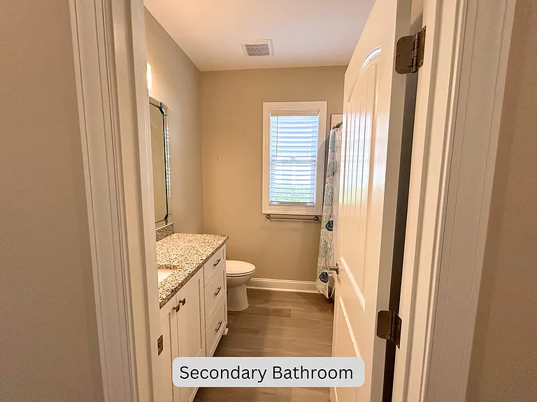 Secondary bathroom off hall connecting secondary bedrooms in this split floor plan home