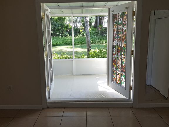 Screened back porch leading to backyard off the primary bedroom