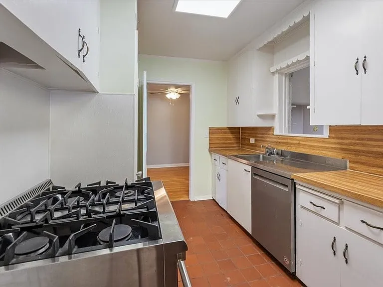 Kitchen with professional-grade gas range, and new stainless dishwasher.