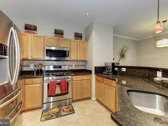 Gourmet Kitchen with bar and granite countertops combined with upgraded stainless steel appliances are an epitome of charm and functionality