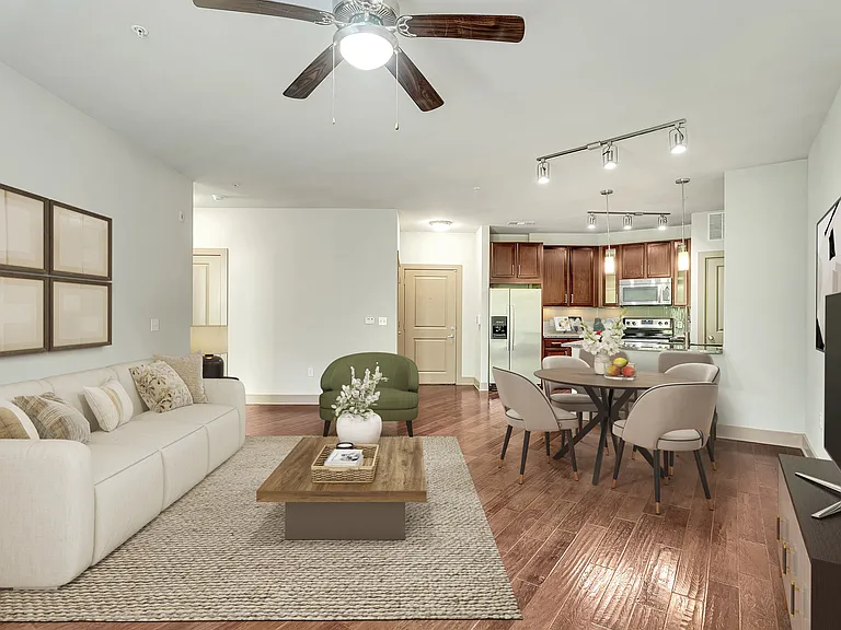 A living room with a white couch, a coffee table, and a ceiling fan.