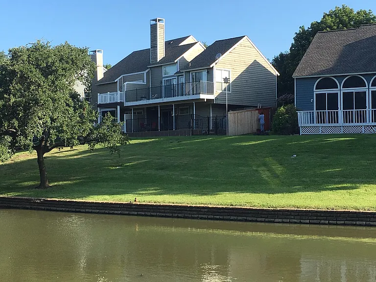 Backside of Home. Proximity to canal is wonderful. You are able to sit under the tree near the canal's edge and picnic.