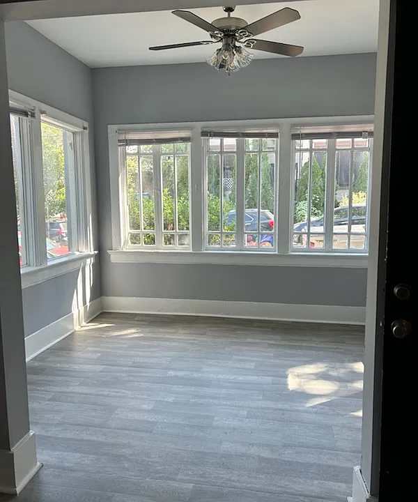 A glowing sunroom with floor-to-ceiling windows, offering a bright, versatile space ideal for meditation, reading, an office, or a cozy den.