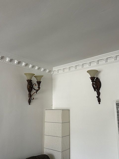 Living room wrought iron wall sconces,
Accented by the Crown molding in living room!