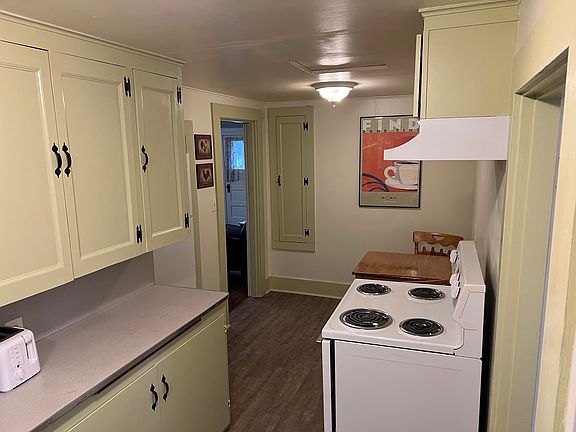 Kitchen with refrigerator, range and dining table with matching chairs