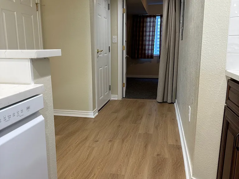 View from kitchen to north bedroom. Tall door on the left leads to the washer/dryer stack.
