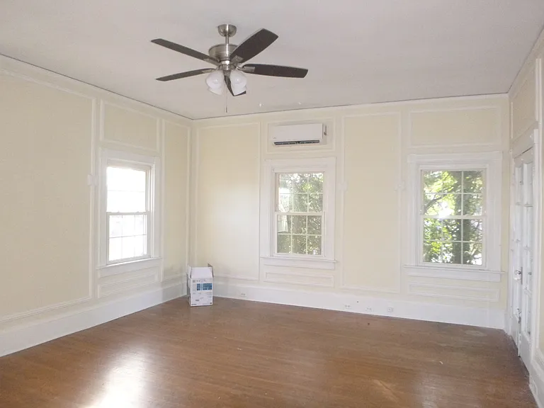 Living Room has high ceilings, lots of natural light, trim work, ceiling fan and a balcony.