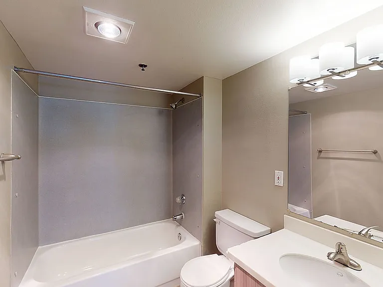 Apartment bathroom with wood-style flooring.
