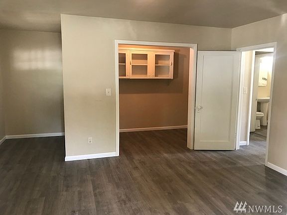Larger unit- Living room looking from kitchen towards entry, bonus or office area, and bedroom and bathroom.