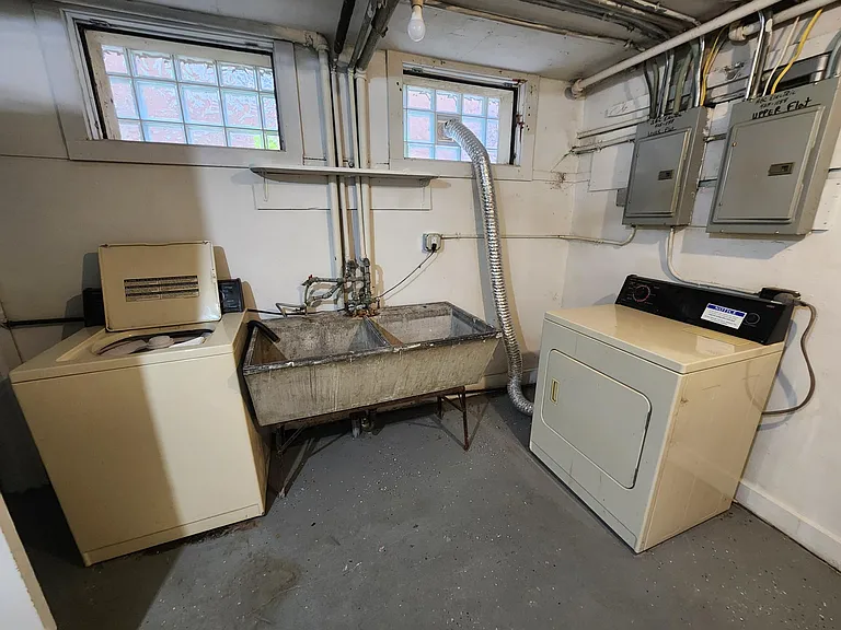 Basement lower unit laundry room washer, dryer, and sink.