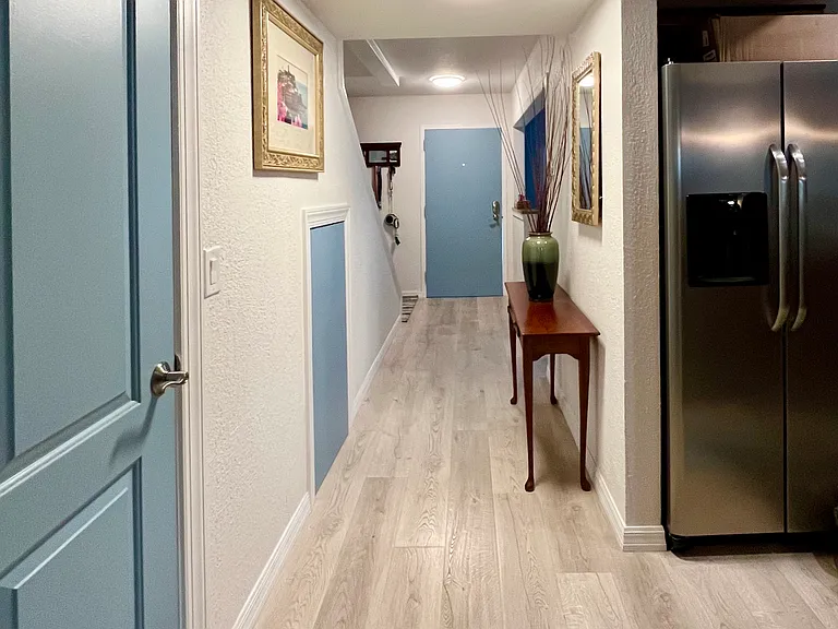 Hallway from living room to front door. Kitchen on the right and 1/2 Bath to the left.