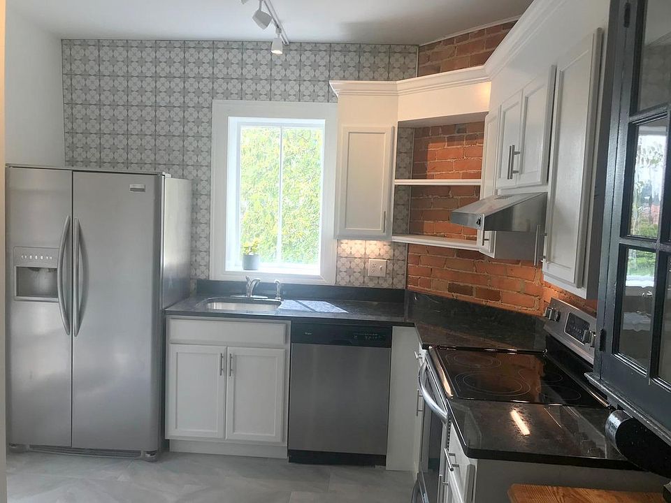 Kitchen with Stainless steel Fridge and Ceramic tile on the back wall.