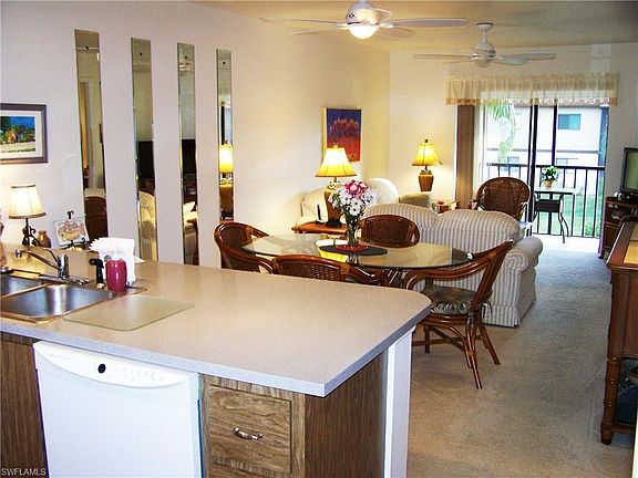 View from entrance -  open concept of the dining/living spaces.  Home is neutrally painted throughout,  Sliding glass doors open