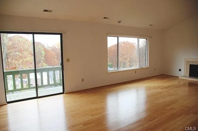 Living room with hardwood floors, peach marble fireplace, and vaulted ceilings. Magnificent views: best in the complex.
