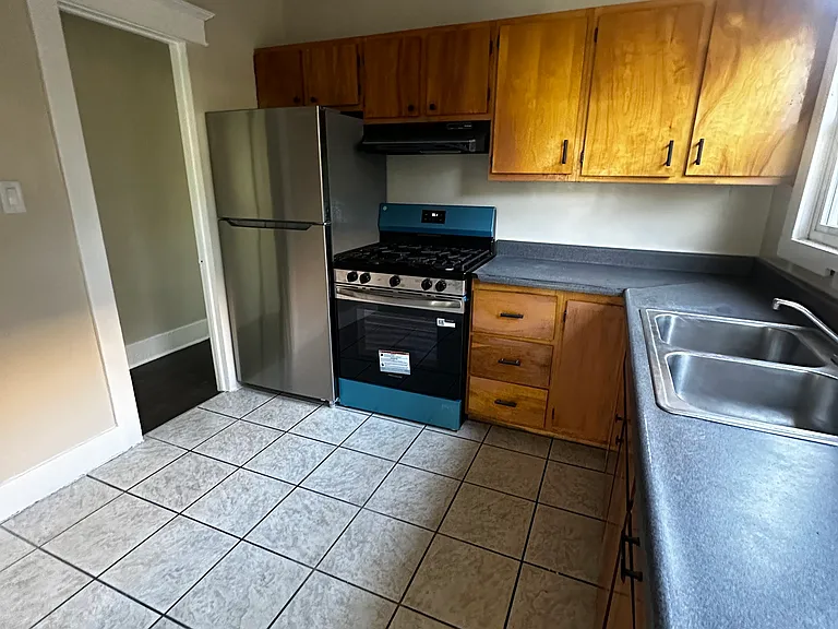 Beutiful kitchen with lots of wood cabinets for storage and cooking.