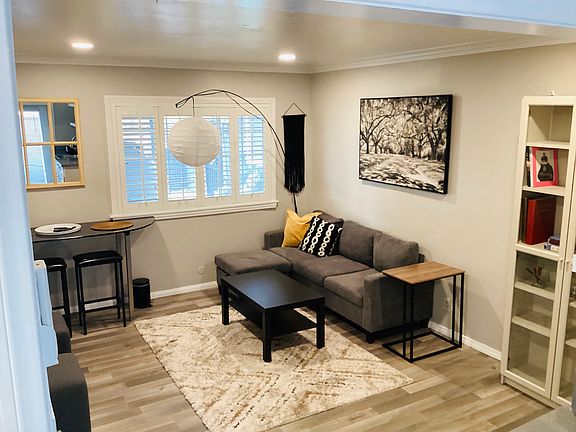 Living room w/ recess lighting and hanging lamp. Comfy sofa w/ storage and a coffee table for your refreshments.