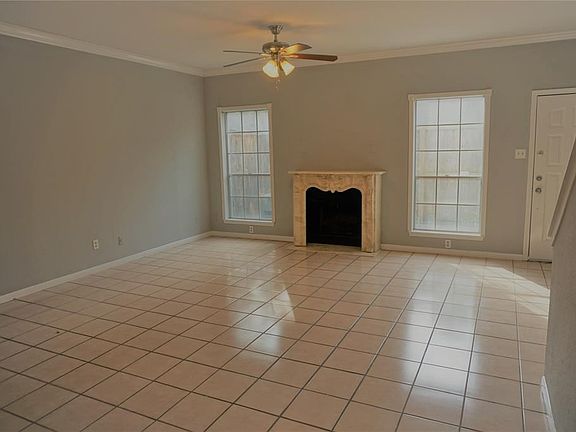 Living room looking from the kitchen. Tile floors and cultured marble wood burning fireplace.