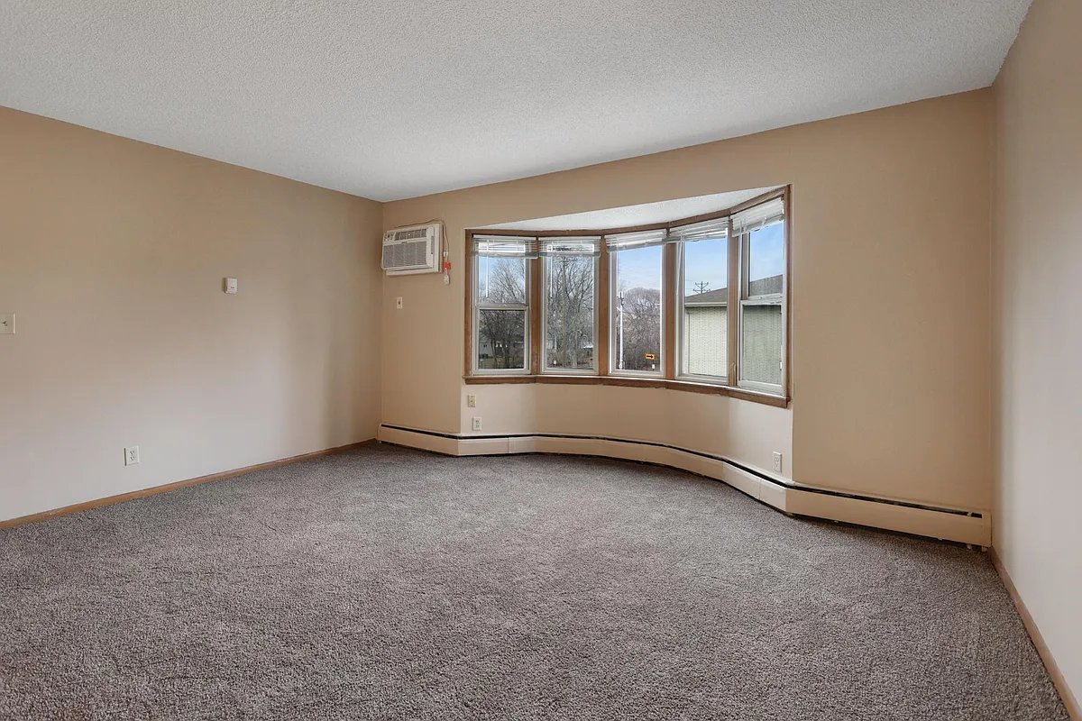 Living room with bay window - Pleasant Apartments
