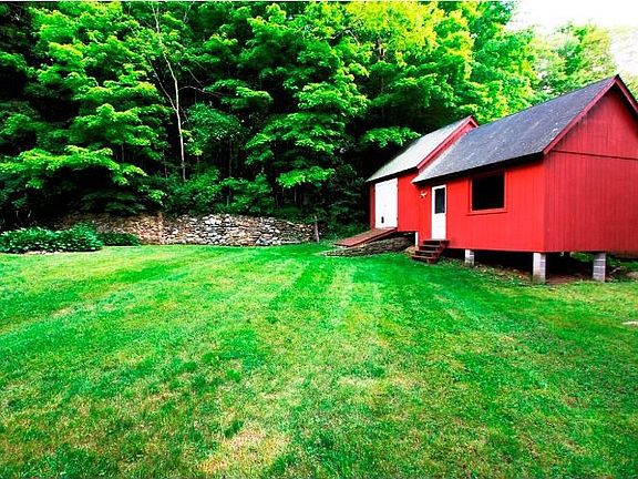 Back yard withl stone wall with 2 outbuildings