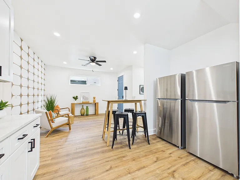 Open kitchen and dining area with stainless steel appliances, ample cabinetry, and a bar-height table for everyday meals.