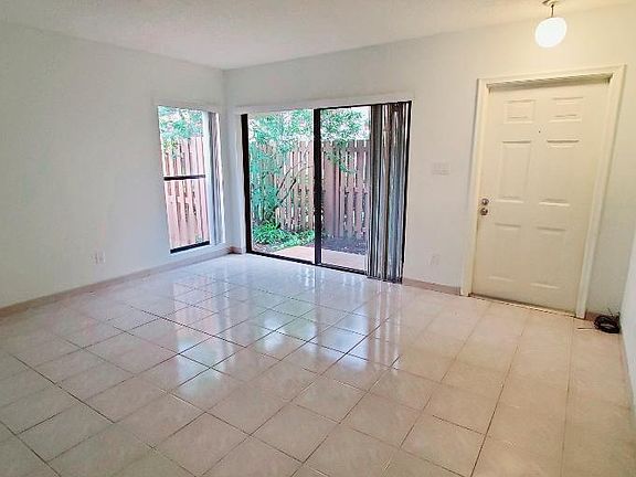 Living room with sliding glass door to private fenced patio in front.
