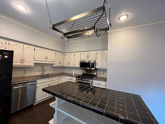 Kitchen view displaying stainless steal and black appliance, and plenty of cabinets space