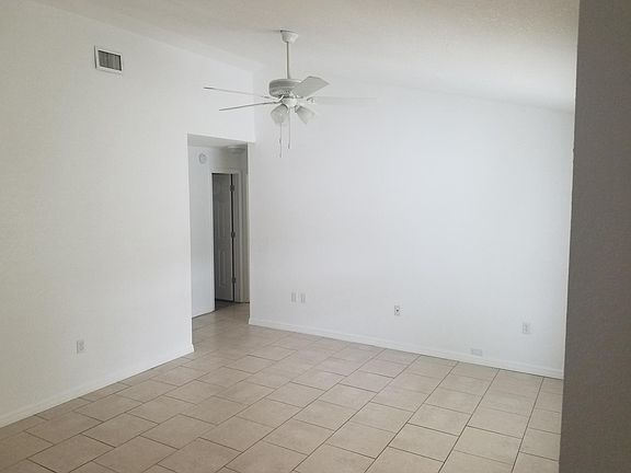 LIVING ROOM looking into hallway, leading to three bedrooms and family bathroom.