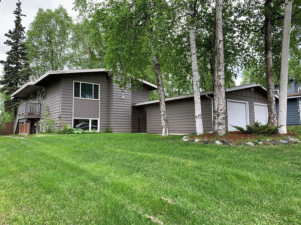 Street view of duplex with garage. Huge yard and beautiful trees