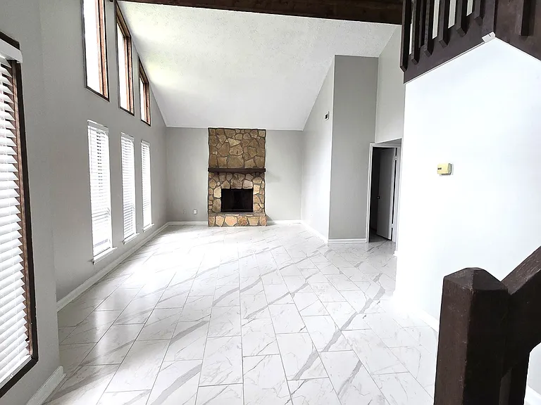 Spacious 2-story high living room with marble look floor