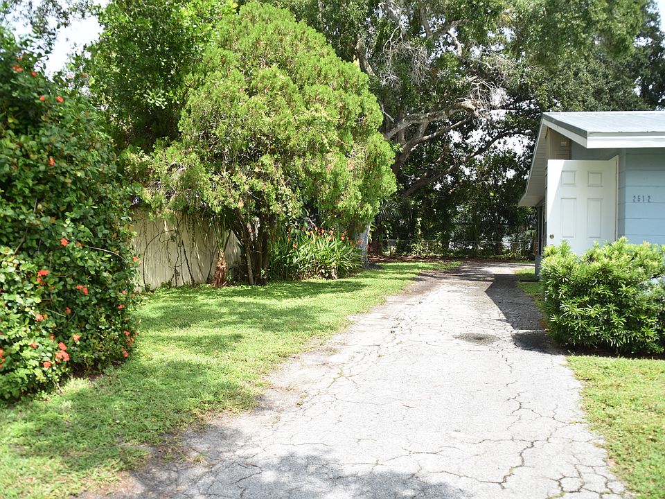Driveway from front, wraps around to right for parking under carport and a small shed for storage