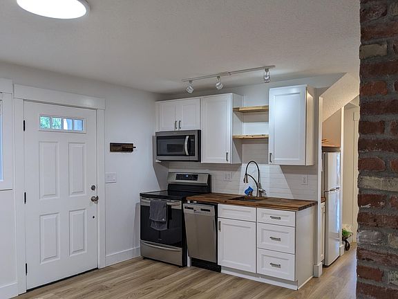 Kitchen next to front door. Kitchen wraps around towards the garage.