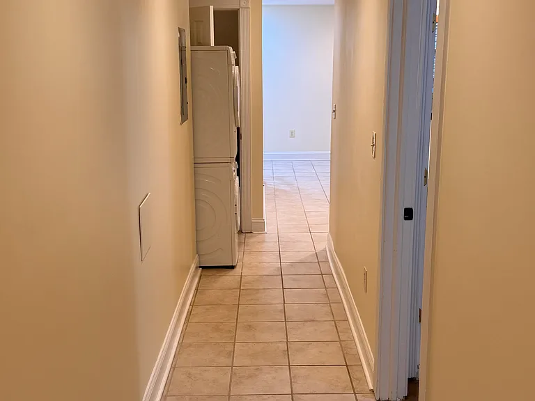 View toward front of unit from hallway. Bedroom door on right.