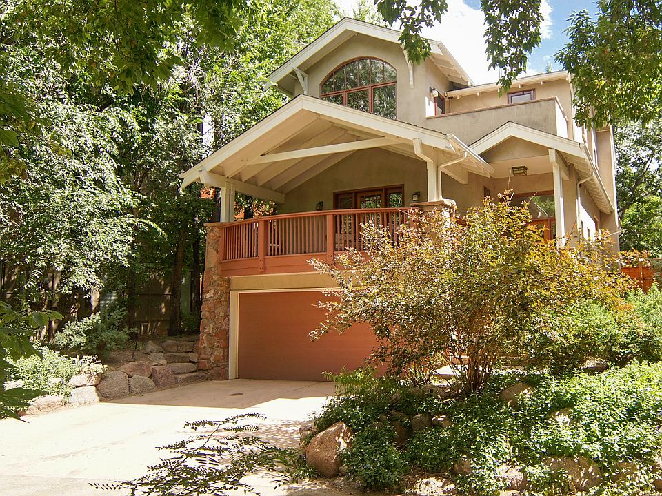 Front of house, Porch and Upstairs balcony overlook Boulder Creek, 2-car garage and 2-car driveway.