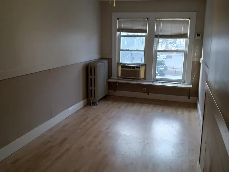 Bedroom with ceiling fan and air conditioner. ( Heat is radiator heat which is included in rent.)