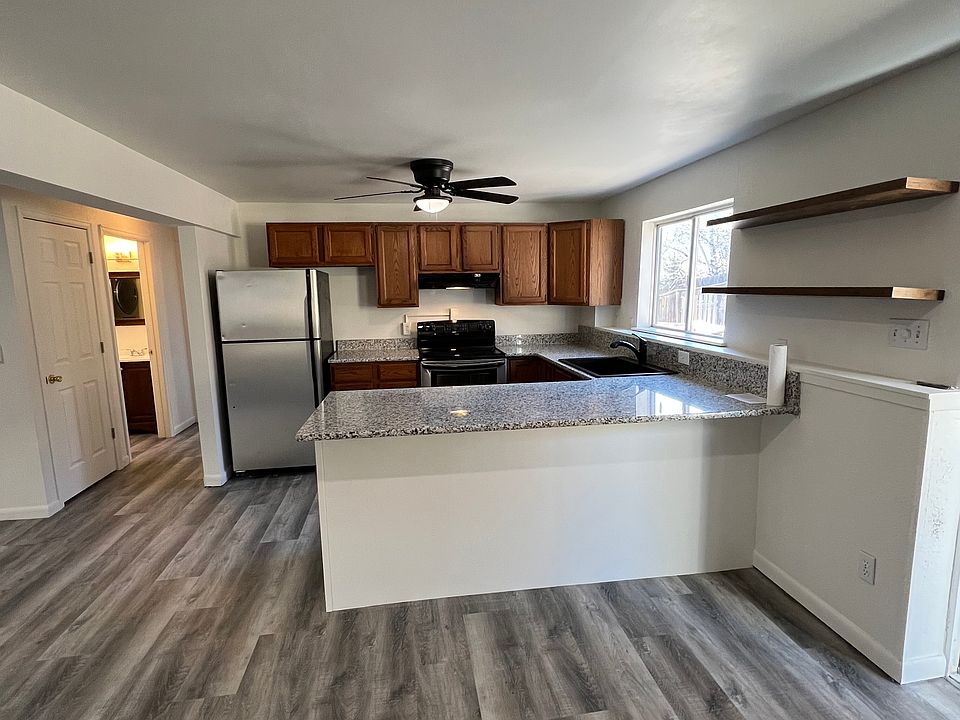 Kitchen with granite countertops and open shelving.