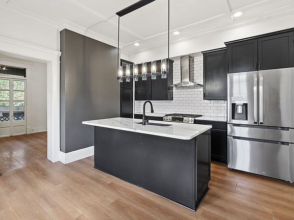 Fully Updated Kitchen with Italian Marble island and countertops. All new High line stainless appliances, Dual Fuel Range, classic subway tile backsplash, New LED Lighting and modern matte black hardware.