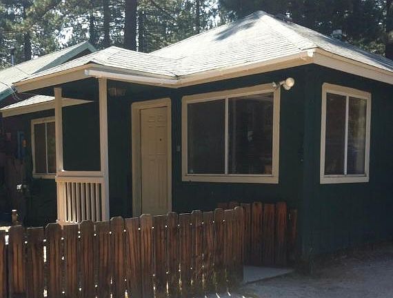 The property was recently painted, and it is no longer dark green. It is now a beige with a red door.
