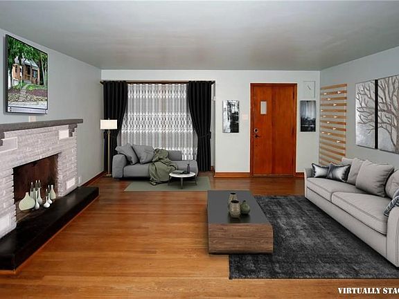 Living room features a stone decorative fireplace,hardwood floors and a large window to allow plentyof natural light into the ho