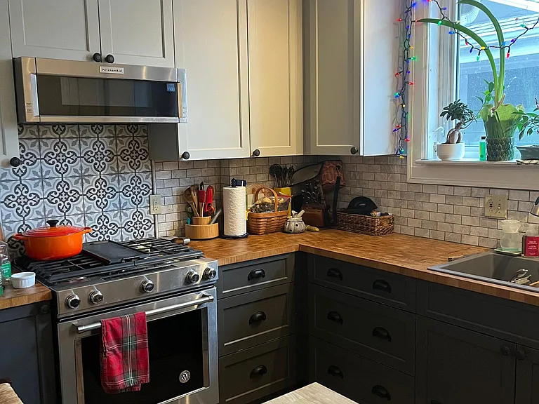 Gas stove, low profile microwave, small island prep area, double kitchen sink and large windows for natural light.