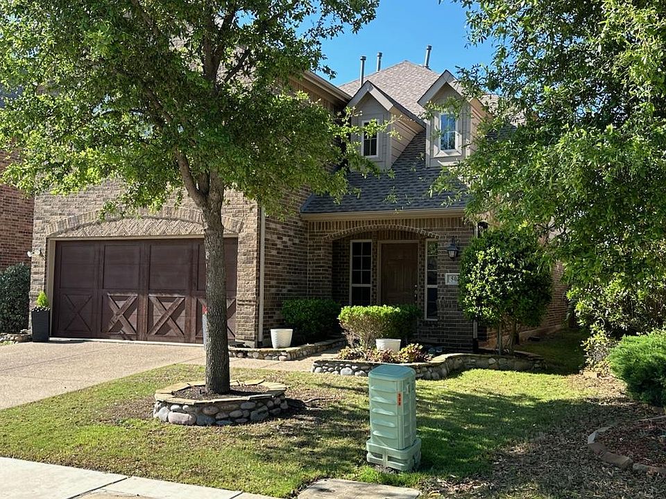 View of front facade featuring a garage and a front yard.