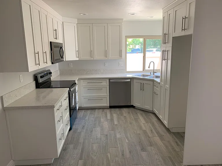 Newly renovated Kitchen, Quartz counter top, porcelain plank tile floor and double pane windows.