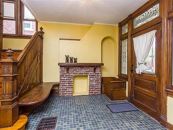 Front entry area with original woodwork, leaded glass and decorative fireplace.