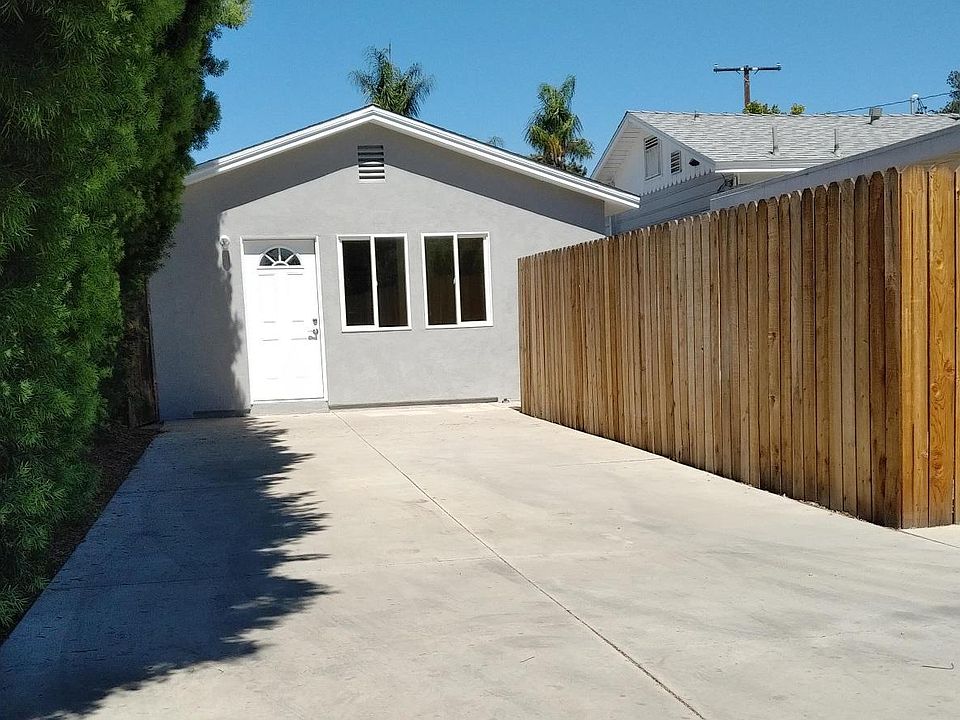 Driveway, front door and windows; patio gate on the left, trash can alcove on the right