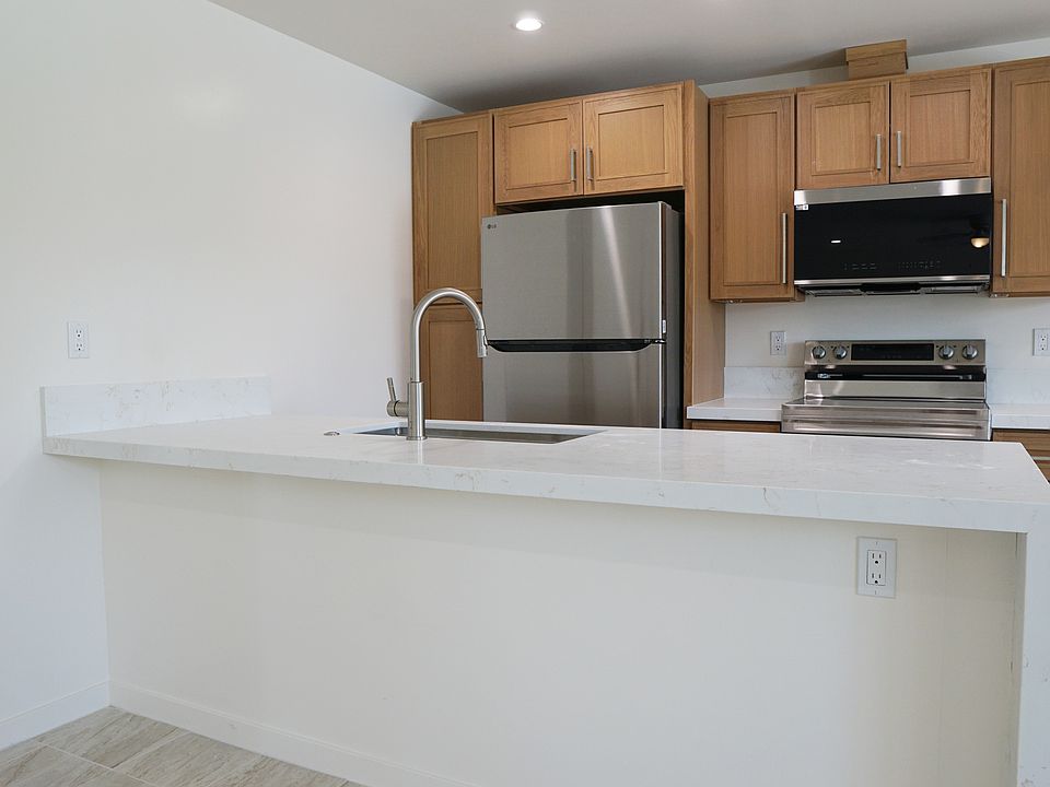 Island kitchen with room for barstools, and a waterfall countertop